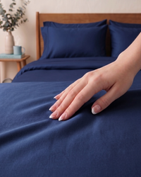 A hand gliding on a luxurious Navy Blue percale Bedsheet