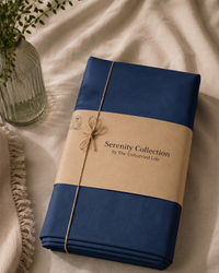 Navy Blue percale bedsheet with brown paper wrap and 'Serenity Collection' label on a beige surface.