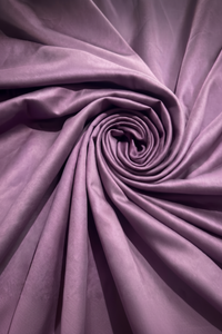 Close-up texture of soft, deep plum percale knit fabric twisted into a tight, dynamic spiral swirl.
