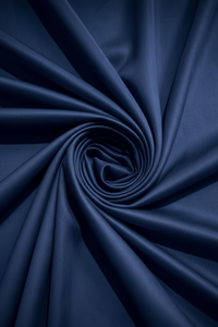 Close-up texture of soft, navy blue percale knit fabric twisted into a tight, dynamic spiral swirl.
