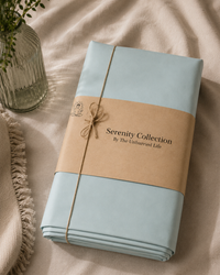 Folded fabric with 'Serenity Collection' label on a beige surface