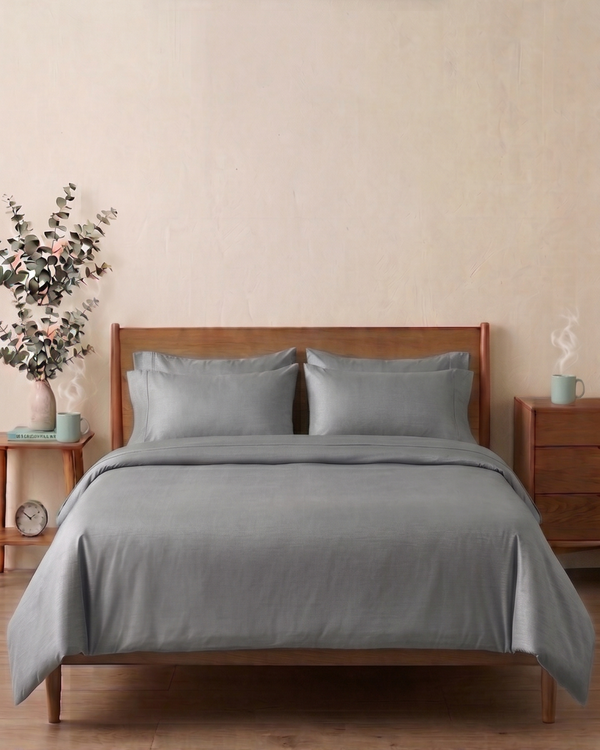 Silver Grey bedding set on a wooden bed with matching headboard and nightstands in a bedroom setting.