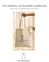 Beige tote bag with 'The Unhurried Life' logo held by a hand against a light curtain background to go with the bedsheets.