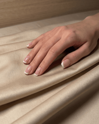 Champagne beige sateen bedsheet styled in a warm minimalist bedroom