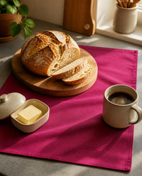 Mulberry pink cotton canvas table mat on a kitchen counter with bread, butter and coffee - The Unhurried Life